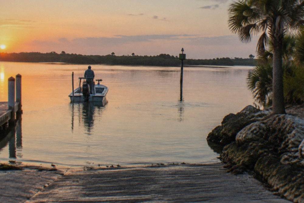 Inshore Florida flats at first light with calm water and distant mangrove shoreline