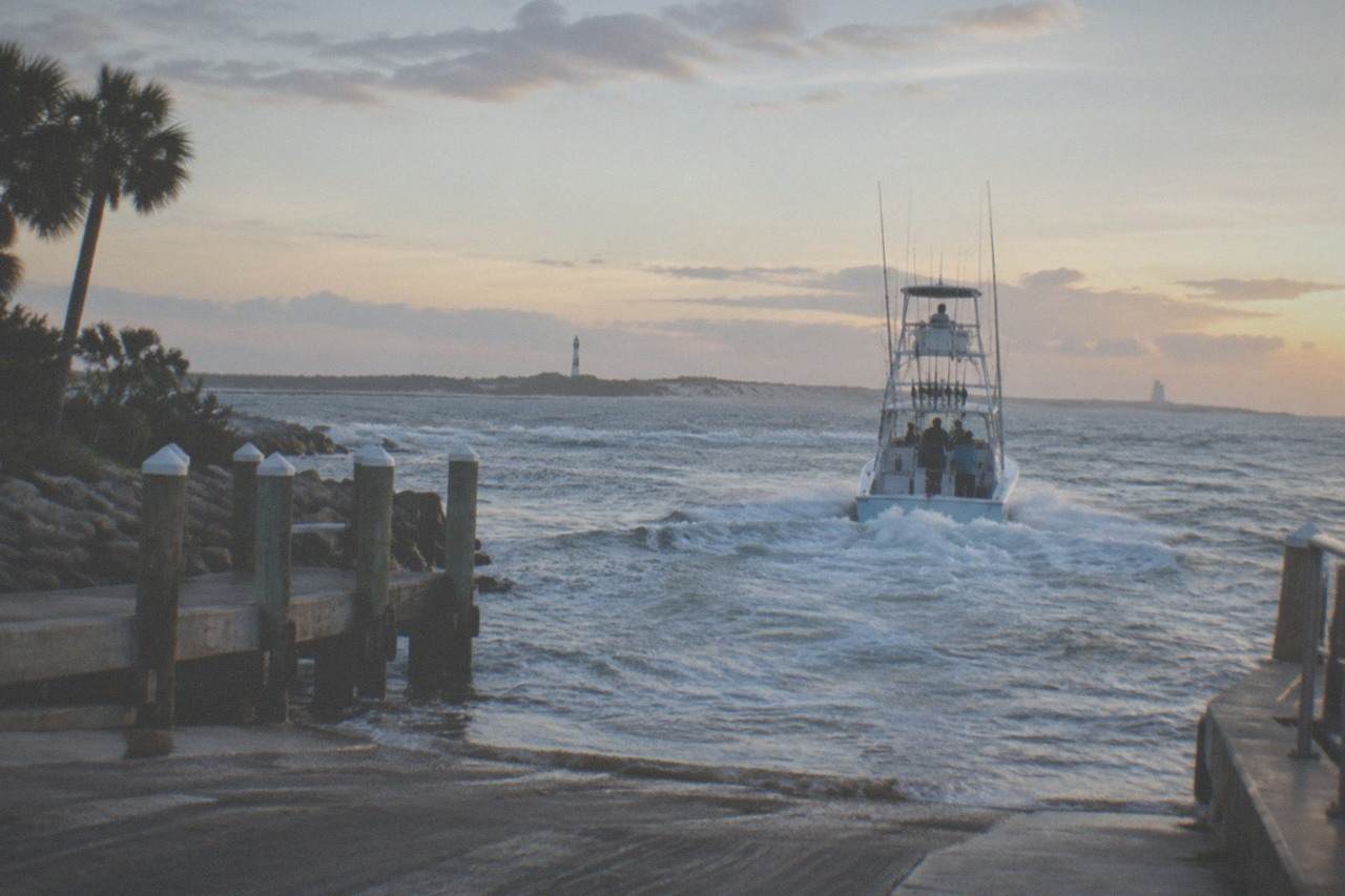 A fishing charter boat cruising open Atlantic water off the Florida coast at first light