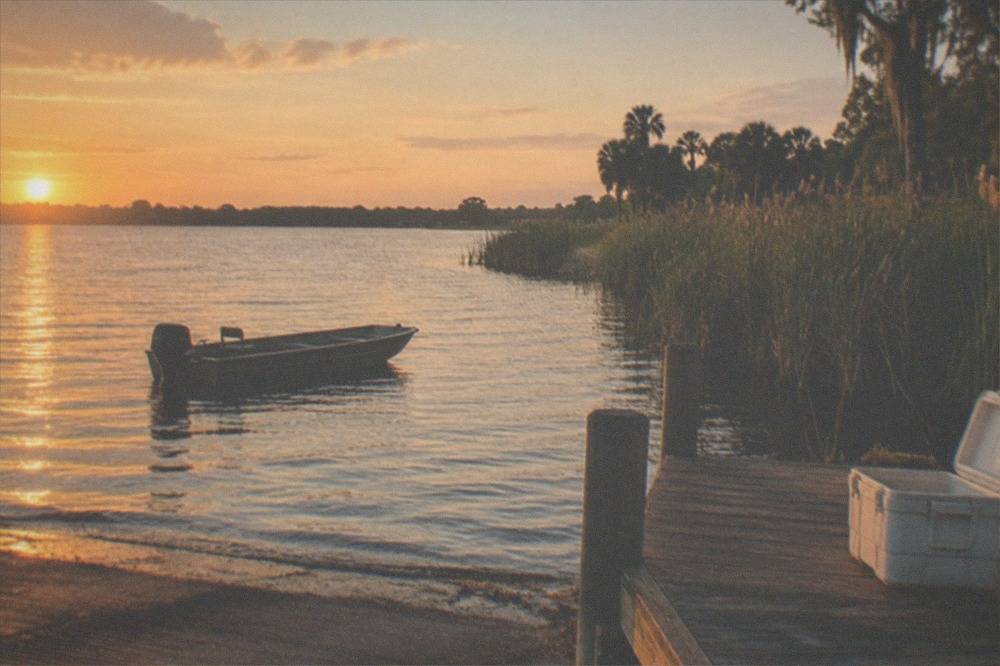 Quiet smaller lake at golden hour with cattails along the bank and no other boats visible