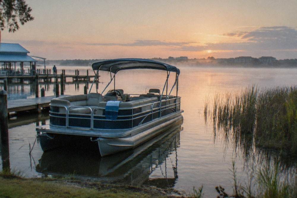 A charter boat anchored near grassy shoreline on a calm Florida morning
