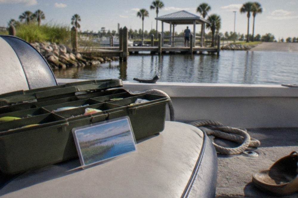 A fishing licence card and a tackle box sitting on a boat seat
