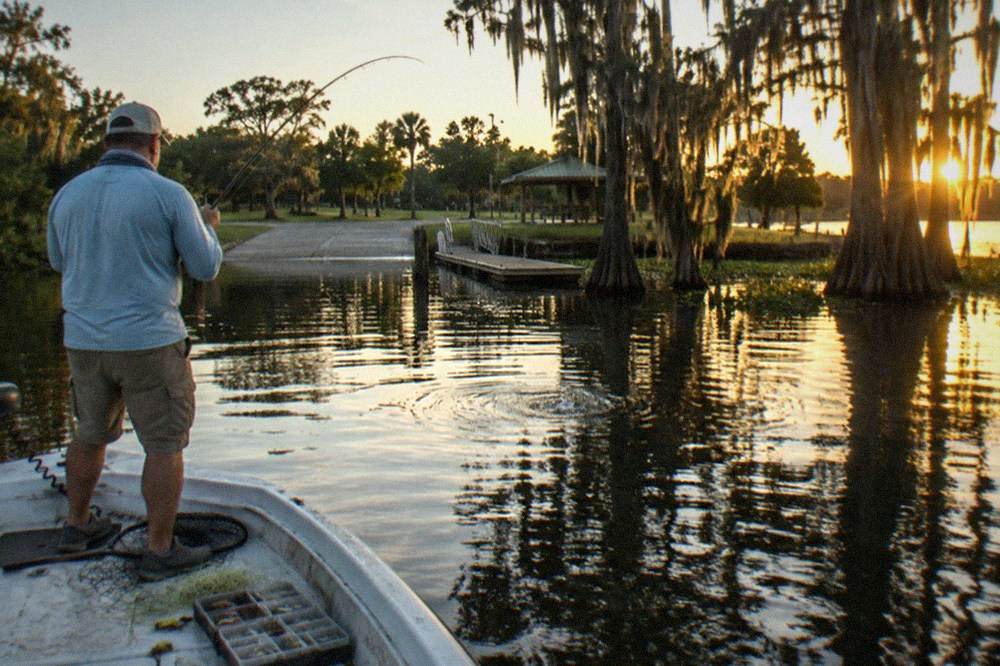 Angler playing a fish on light tackle from the deck of a small charter boat