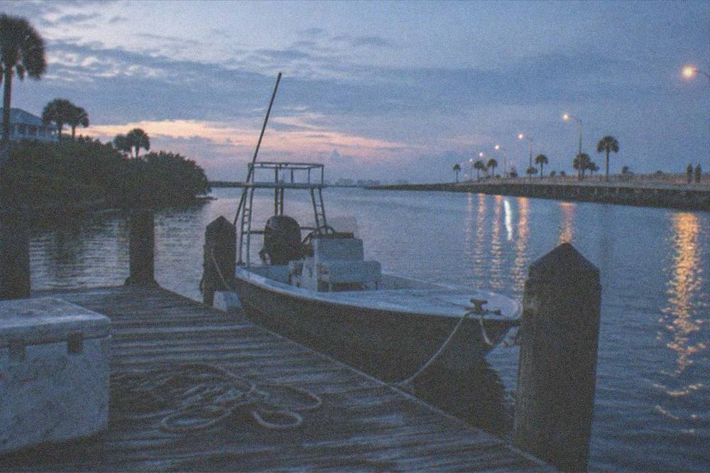 Small flats boat tied at a dock before sunrise on the lagoon