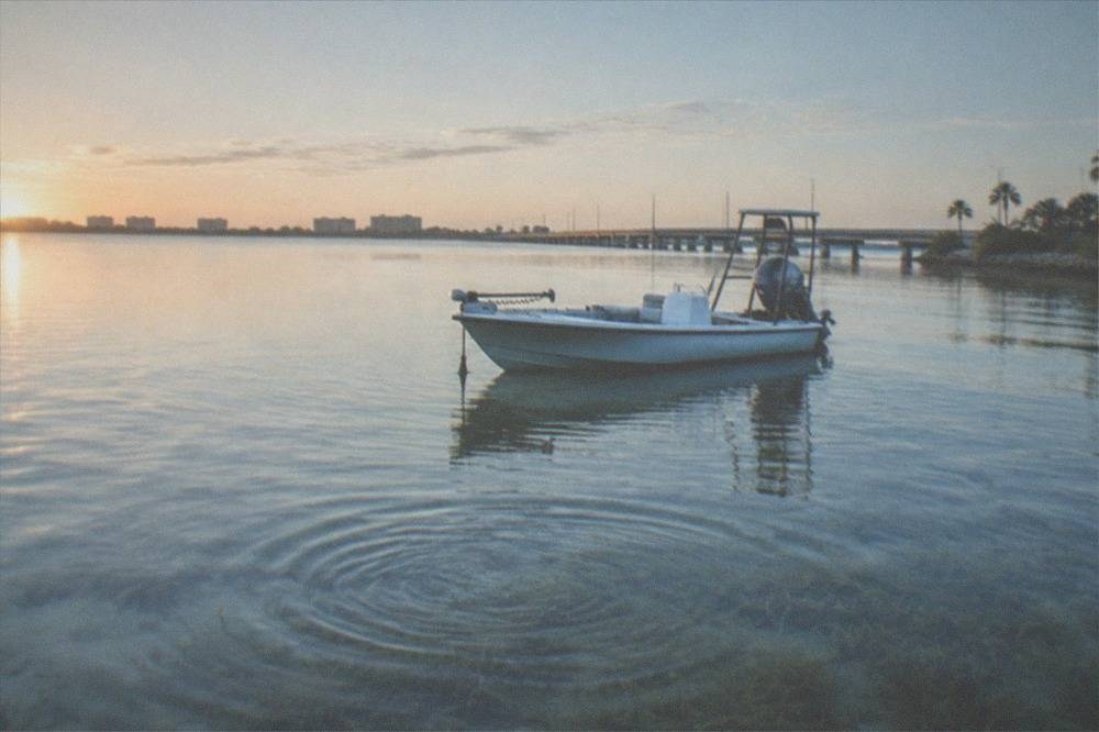 Skiff drifting over a shallow flat in early morning light