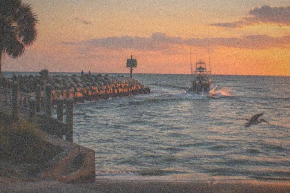 An offshore charter boat running out past a breakwater toward open Atlantic water