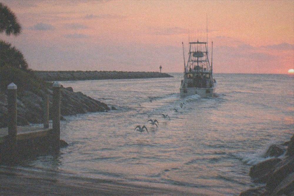 offshore fishing boat running out past the Port Canaveral jetty at first light