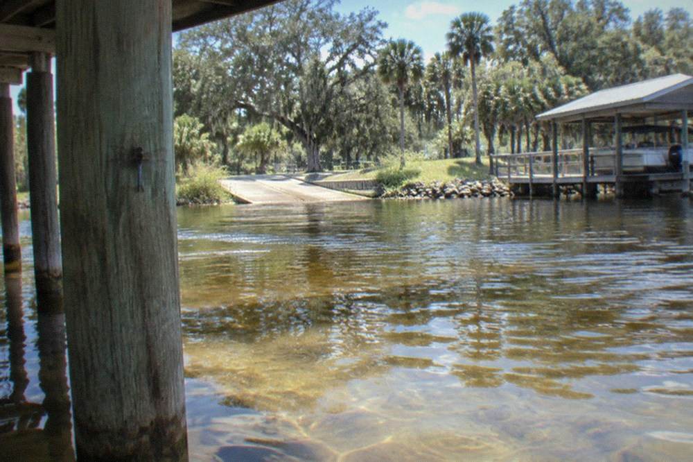 Clear water lake with dock and boat houses along a wooded shoreline in central Florida