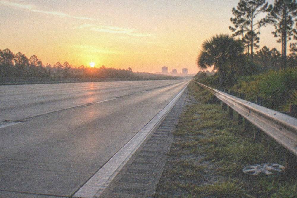 Florida highway at dawn with an empty road heading east toward the coast